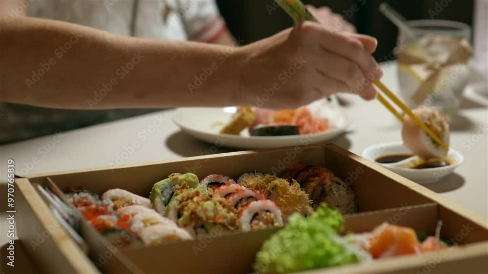 Anonymous woman eating sushi with soy sauce, selective focus shot with beautiful blur Anonymous woman eating sushi with soy sauce, selective focus shot with beautiful blur