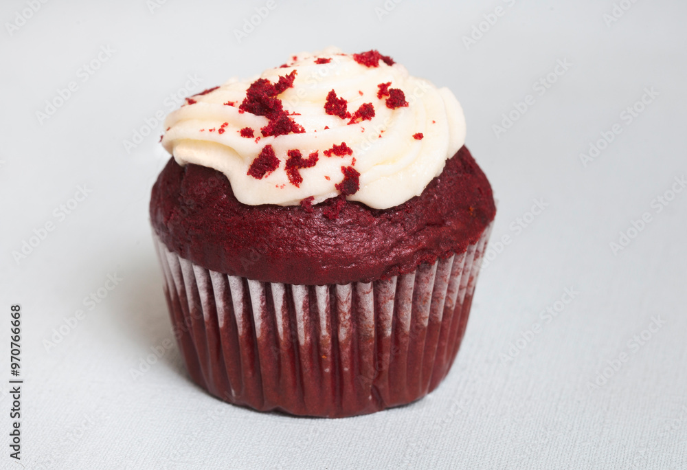 Single red velvet cupcake on light pastel blue with selective focus and copy space Single red velvet cupcake on light pastel blue with selective focus and copy space