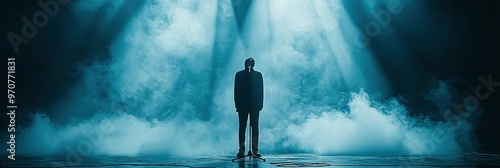 Silhouette of a Man Standing on Stage with Smoke and Spotlights photo