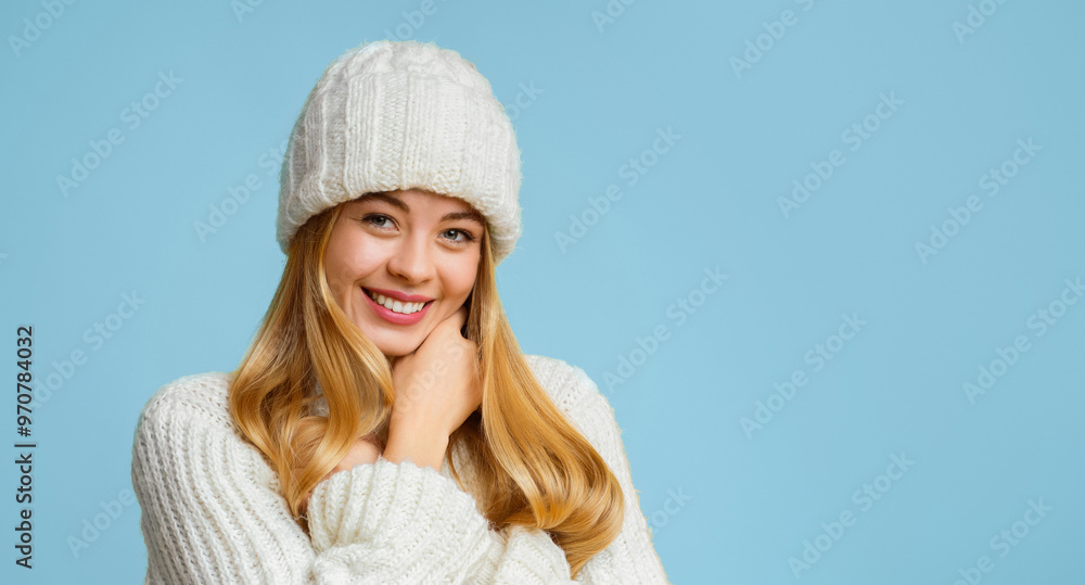 Portrait of attractive smiling girl in white knitted hat over yellow background, touching her chin, panorama with copy space Portrait of attractive smiling girl in white knitted hat over yellow background, touching her chin, panorama with copy space