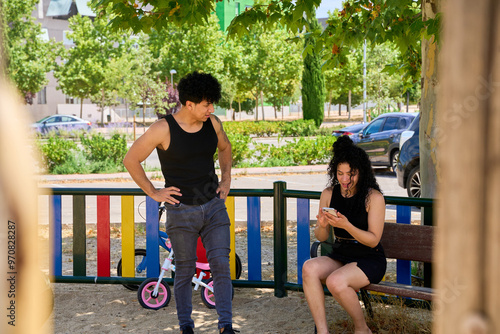 latin couple sitting on a bench in the park photo