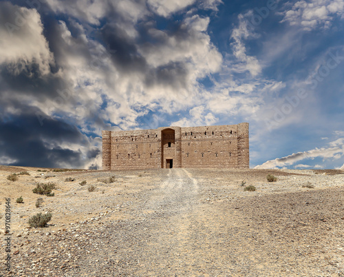 Qasr Kharana (Kharanah or Harrana)-- desert castle in eastern Jordan (100 km of Amman). Built in 8th century AD to be used as caravanserai, a resting place for traders. Against the sky with clouds photo