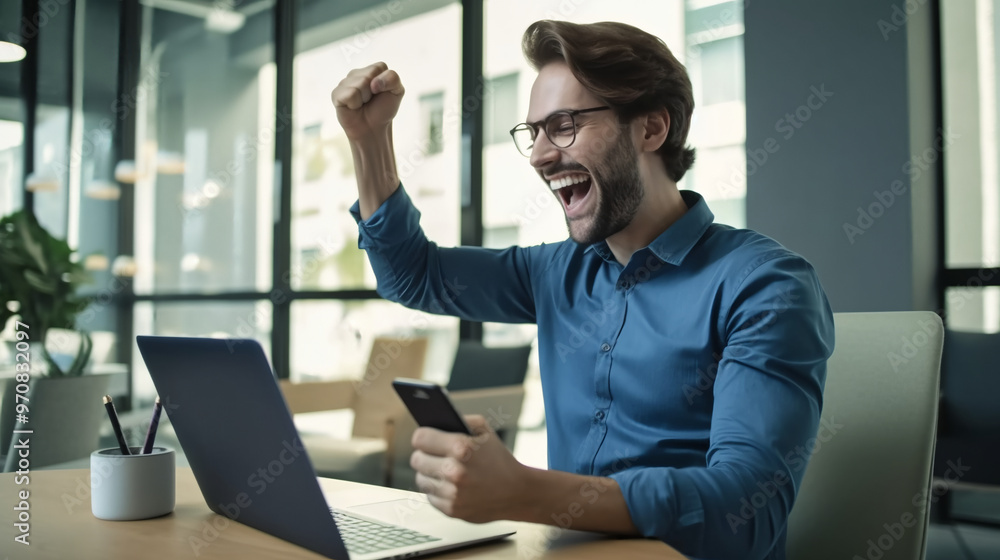A happy man sitting at his desk raising his hands in celebration. A happy man sitting at his desk raising his hands in celebration.