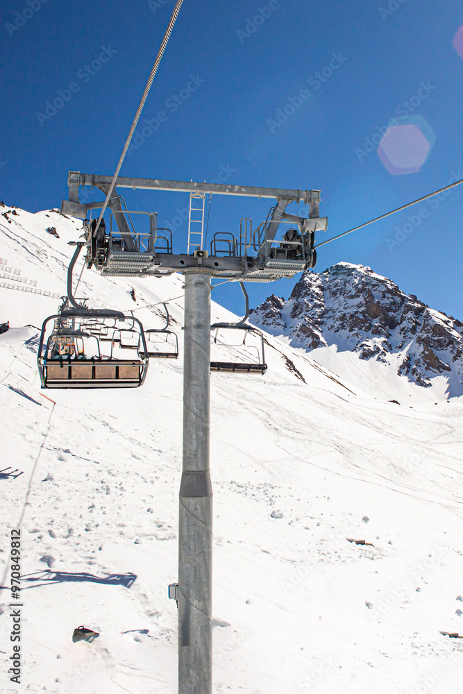 Banner panorama of ski resort, skiers on the ski lift, white snow pine trees at pink sunset or dawn Banner panorama of ski resort, skiers on the ski lift, white snow pine trees at pink sunset or dawn