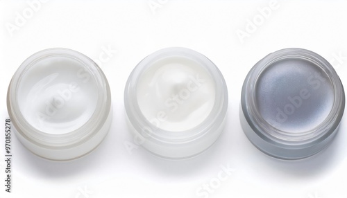 Three jars of various cosmetic creams rest on a white tabletop