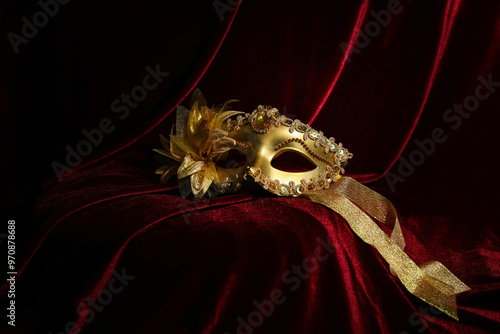 Beautiful golden carnival mask on red silk fabric