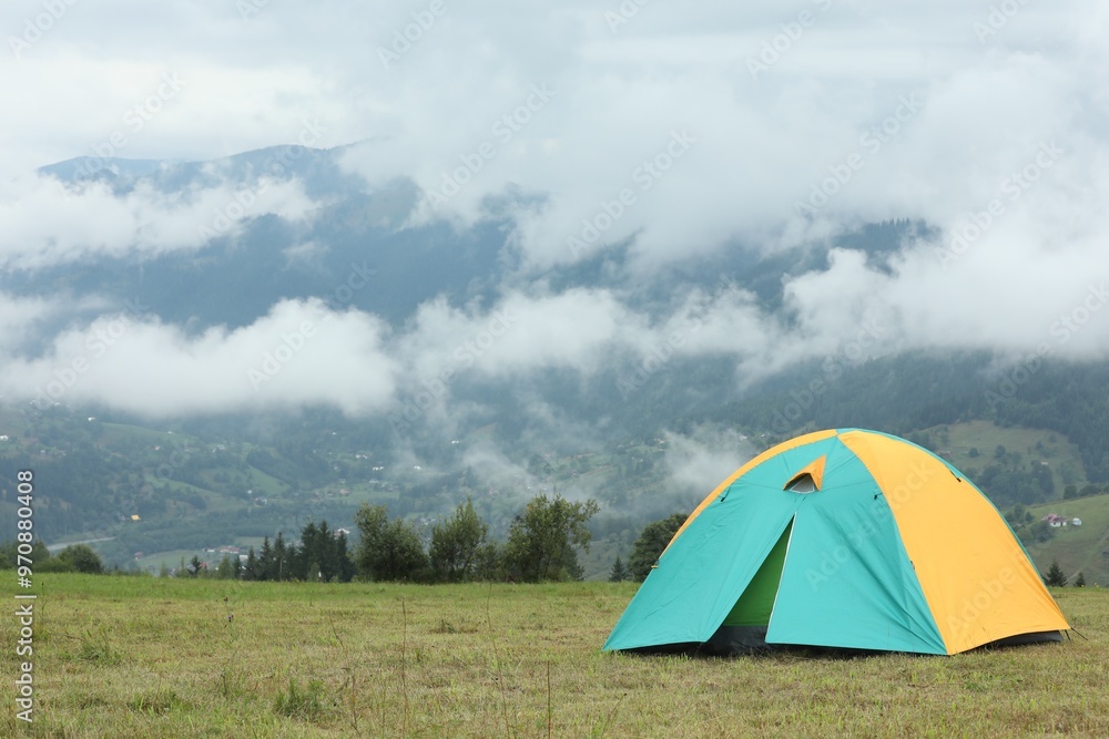 Camping tent on green grass in mountains, space for text Camping tent on green grass in mountains, space for text