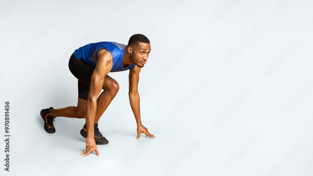 Time To Start. Muscular black sportsman preparing for a run, looking up at copyspace, panorama, yellow studio wall Time To Start. Muscular black sportsman preparing for a run, looking up at copyspace, panorama, yellow studio wall