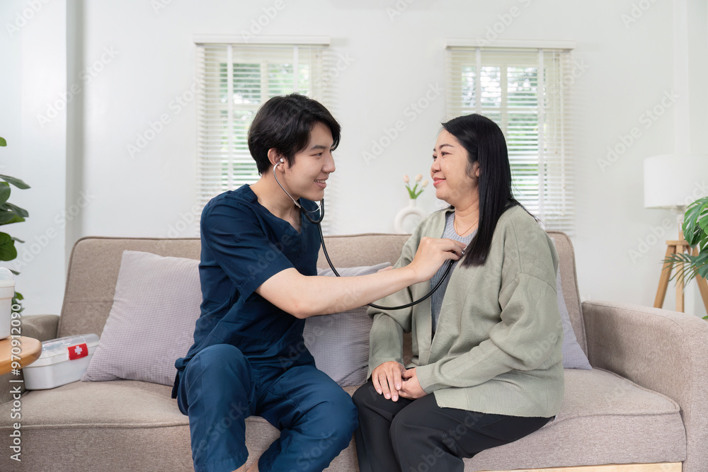 Young Male Nurse Using Stethoscope to Check Elderly Woman's Heartbeat at Home in a Bright Living Room Young Male Nurse Using Stethoscope to Check Elderly Woman's Heartbeat at Home in a Bright Living Room