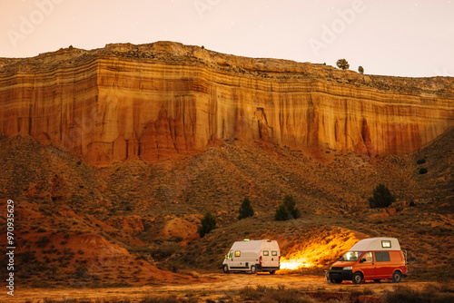 Fotografie Two vans are parked next to each other in the desert at night.