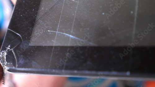 Close-up of a tablet with a cracked screen. Focus on the damage to the glass surface photo