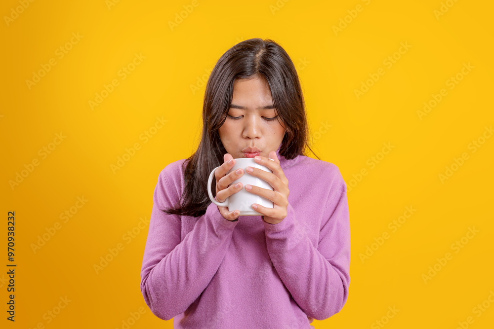 Young Asian Woman Wear Casual Warm Clothes Blowing Hot Water Isolated On Yellow Background Young Asian Woman Wear Casual Warm Clothes Blowing Hot Water Isolated On Yellow Background