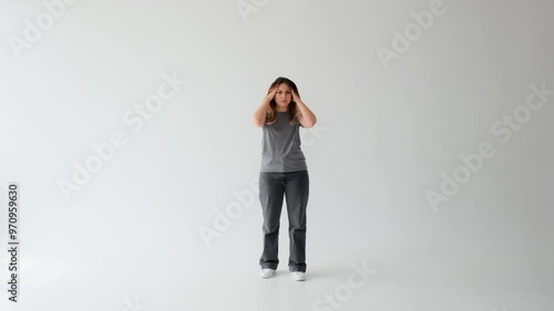 Sad Caucasian young adult woman suffering from headache on white background. Concept of a health problem, exhaustion, annoyance and anxiety.