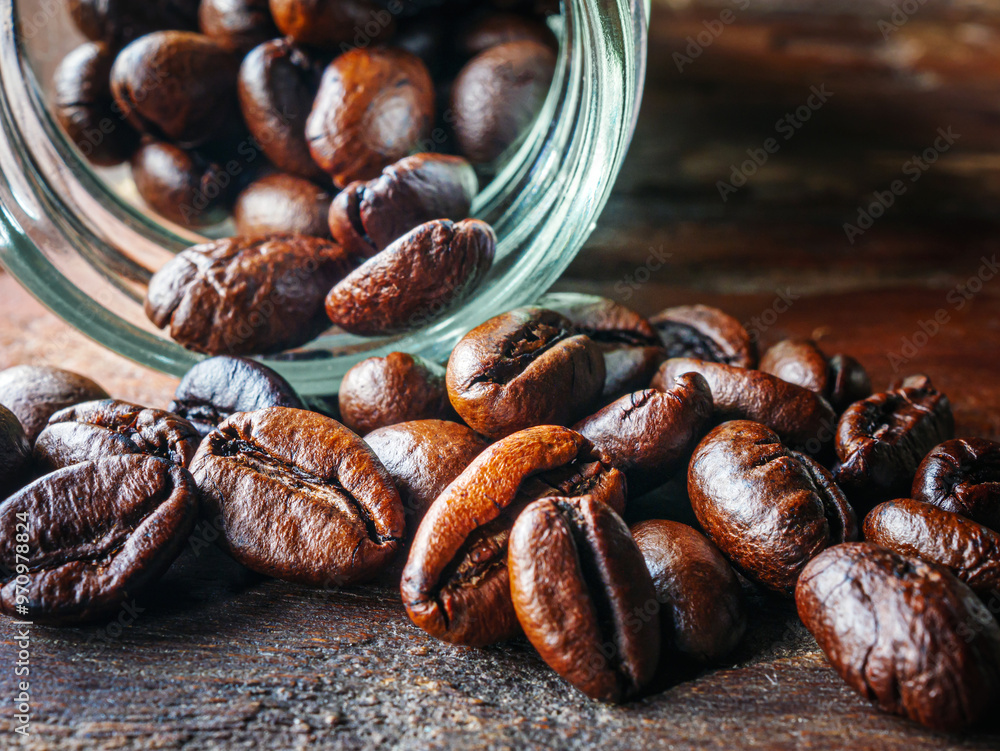Close-up of roasted coffee beans poured out of a glass jar, Coffee beans spilled out from jar,Close up Close-up of roasted coffee beans poured out of a glass jar, Coffee beans spilled out from jar,Close up