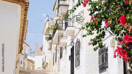 Beautiful narrow street with white facade houses in coastal historical town Altea, Spain