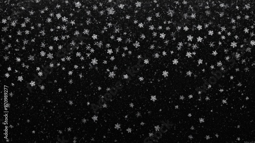 Beautiful snowfall captured against a dark background, showcasing intricate snowflakes floating through the air. Perfect for winter themes, Christmas, or nature-related designs.