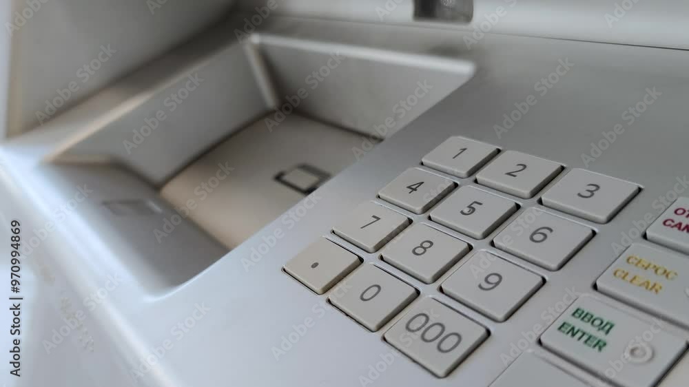 Female hand entering pin code on ATM keypad and putting money in money slot Female hand entering pin code on ATM keypad and putting money in money slot