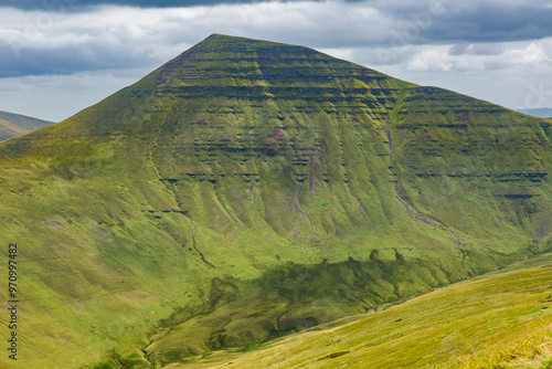 Towering green mountain peak on a summers day photo