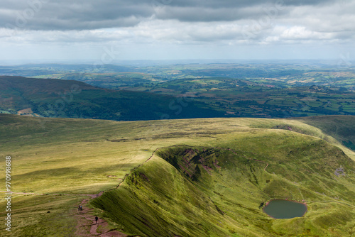 Small glacial lake beneath high mountains (Cwm Llwch, Brecon Beacons) photo