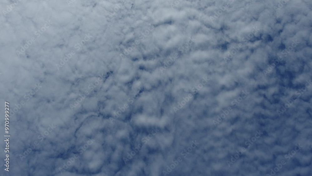 a view of the sky filled with a layer of clouds. The clouds appear to be a type of stratocumulus, which are low, lumpy clouds that cover the sky in a blanket-like formation a view of the sky filled with a layer of clouds. The clouds appear to be a type of stratocumulus, which are low, lumpy clouds that cover the sky in a blanket-like formation