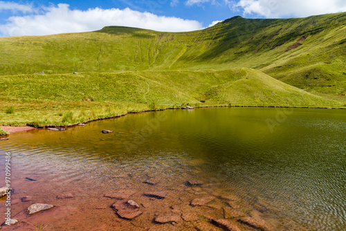 A glacial formed lake under twin mountain peaks (Cwm Llwch, Brecon Beacons, Wales) photo