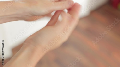 A woman applies cream to her hands. Rubbing cream into the skin of her hands. Dry skin on her hands requires additional care. Applying cream to her hands.