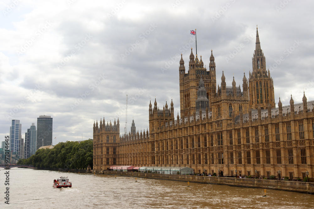 Der Palace of Westminster am Themseufer in London unter grauem Himmel