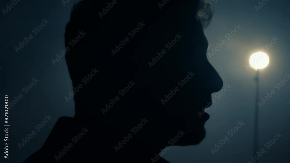 Silhouette of a man at dusk with a mysterious glow in the background Silhouette of a man at dusk with a mysterious glow in the background