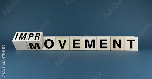 A conceptual image featuring wooden blocks spelling out IMPROVEMENT and MOVEMENT