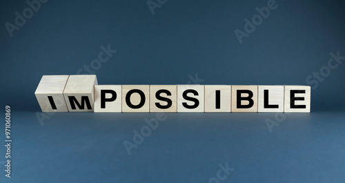 A minimalist image of wooden blocks arranged to form the words IMPOSSIBLE and POSSIBLE