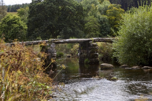 Die alte Postbridge Clapper Brücke führt über den East-Dart Fluss im Dartmoor Nationalpark bei Postbridge in der Grafschaft Devon, Großbritannien photo