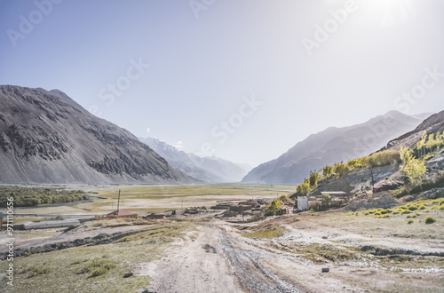 Valley Wakhan corridor and the confluence of the Panj and Pamir rivers surrounded by high rocky mountains with snow in Tajikistan, landscape on Pamra in the Tien Shan Mountains on the Pamir Highway photo