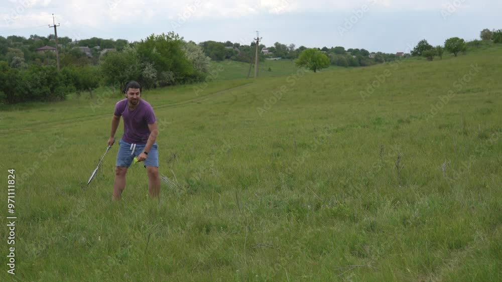 Friends Playing Badminton in a Scenic Green Field Friends Playing Badminton in a Scenic Green Field