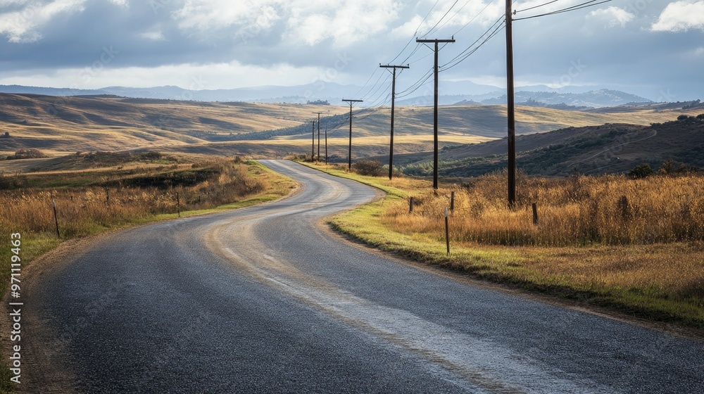A winding road through a countryside landscape, with electric poles dotting the path. A winding road through a countryside landscape, with electric poles dotting the path.