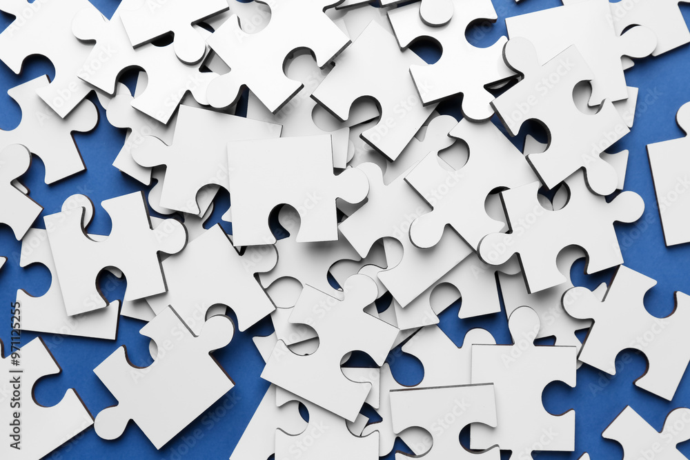 White puzzle pieces on blue background, top view