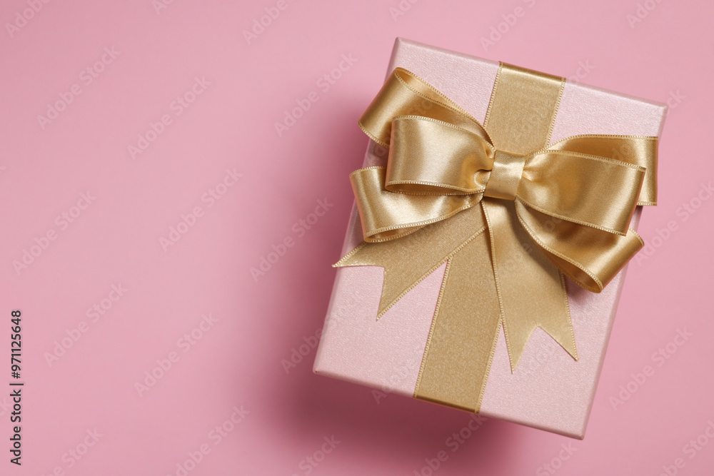 Gift box with bow on dusty pink background, top view Gift box with bow on dusty pink background, top view
