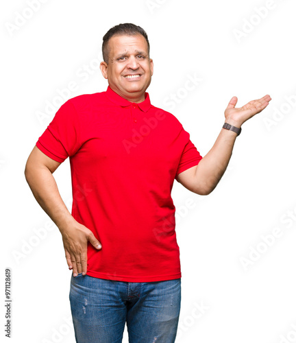 Middle age arab man over isolated background smiling cheerful presenting and pointing with palm of hand looking at the camera.