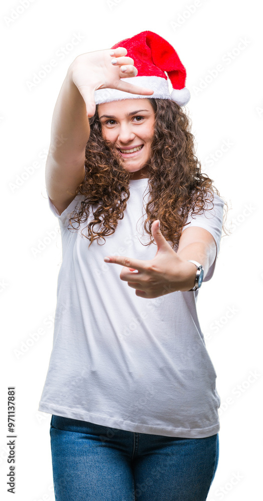 Young brunette girl wearing christmas hat over isolated background smiling making frame with hands and fingers with happy face. Creativity and photography concept. Young brunette girl wearing christmas hat over isolated background smiling making frame with hands and fingers with happy face. Creativity and photography concept.