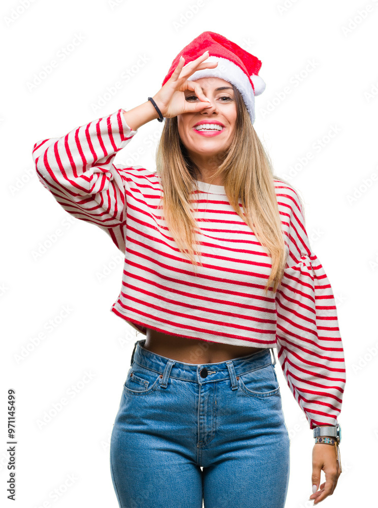 Young beautiful woman wearing christmas hat over isolated background doing ok gesture with hand smiling, eye looking through fingers with happy face. Young beautiful woman wearing christmas hat over isolated background doing ok gesture with hand smiling, eye looking through fingers with happy face.