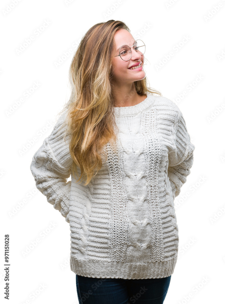 Young beautiful blonde woman wearing winter sweater and sunglasses over isolated background looking away to side with smile on face, natural expression. Laughing confident. Young beautiful blonde woman wearing winter sweater and sunglasses over isolated background looking away to side with smile on face, natural expression. Laughing confident.