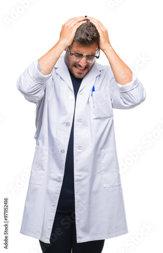 Young handsome man wearing doctor, scientis coat over isolated background suffering from headache desperate and stressed because pain and migraine. Hands on head.