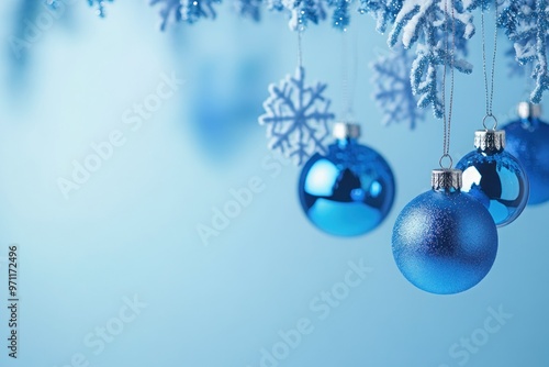 Blue Christmas Ornaments Hanging from a Snowy Branch