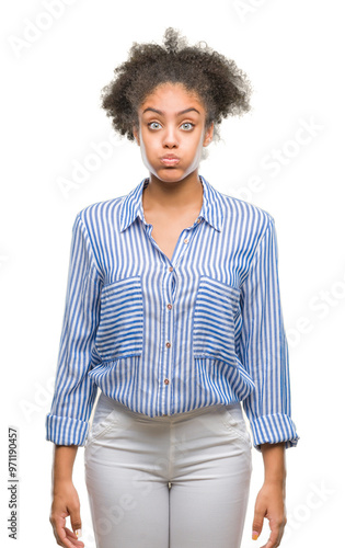 Young afro american woman over isolated background puffing cheeks with funny face. Mouth inflated with air, crazy expression.