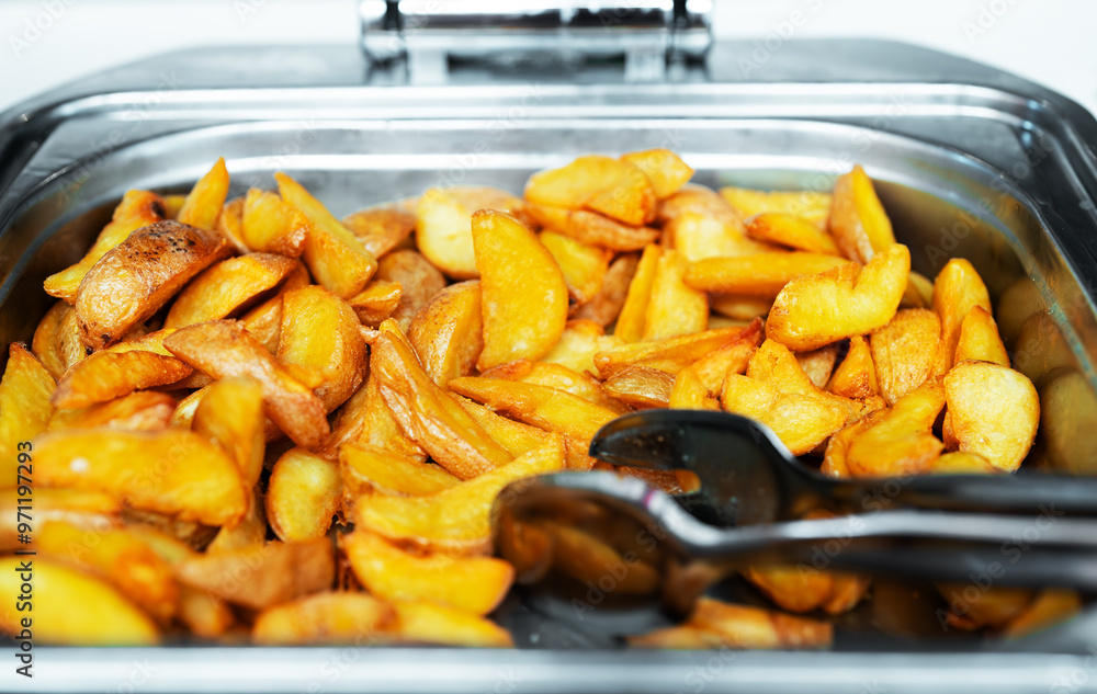 Baked potato slices in a metal tray. Baked potato slices in a metal tray.