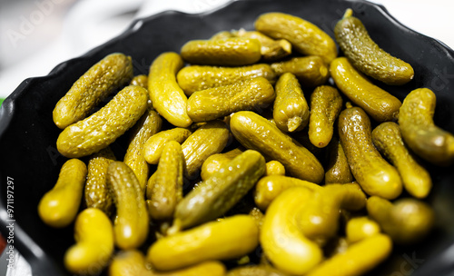 Lots of small pickled gherkins in a bowl. photo