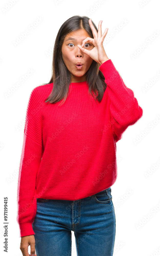 Young asian woman wearing winter sweater over isolated background doing ok gesture shocked with surprised face, eye looking through fingers. Unbelieving expression. Young asian woman wearing winter sweater over isolated background doing ok gesture shocked with surprised face, eye looking through fingers. Unbelieving expression.
