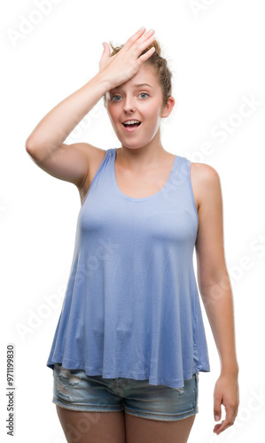 Young blonde woman surprised with hand on head for mistake, remember error. Forgot, bad memory concept.