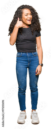 Young beautiful woman with curly hair smiling doing phone gesture with hand and fingers like talking on the telephone. Communicating concepts.