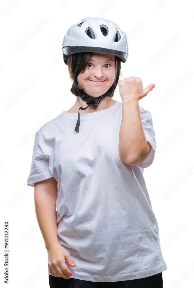 Young adult cyclist woman with down syndrome wearing safety helmet over isolated background smiling with happy face looking and pointing to the side with thumb up. Young adult cyclist woman with down syndrome wearing safety helmet over isolated background smiling with happy face looking and pointing to the side with thumb up.