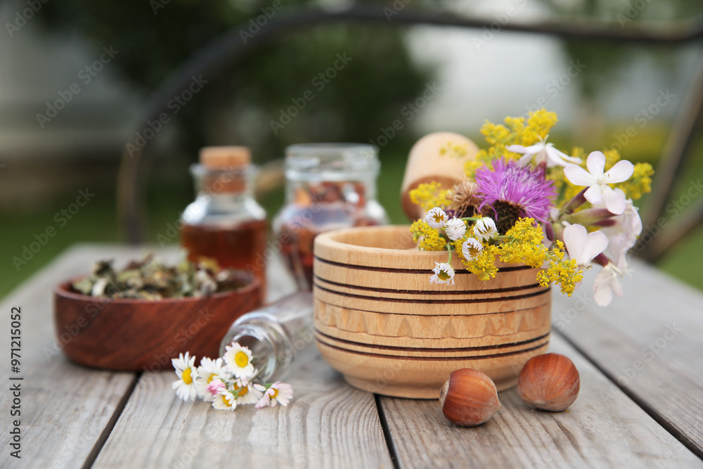 Different ingredients for tincture, mortar and pestle on wooden bench outdoors Different ingredients for tincture, mortar and pestle on wooden bench outdoors